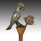 语言学家的手杖，描绘一只鹦鹉拿着尖刺的水果